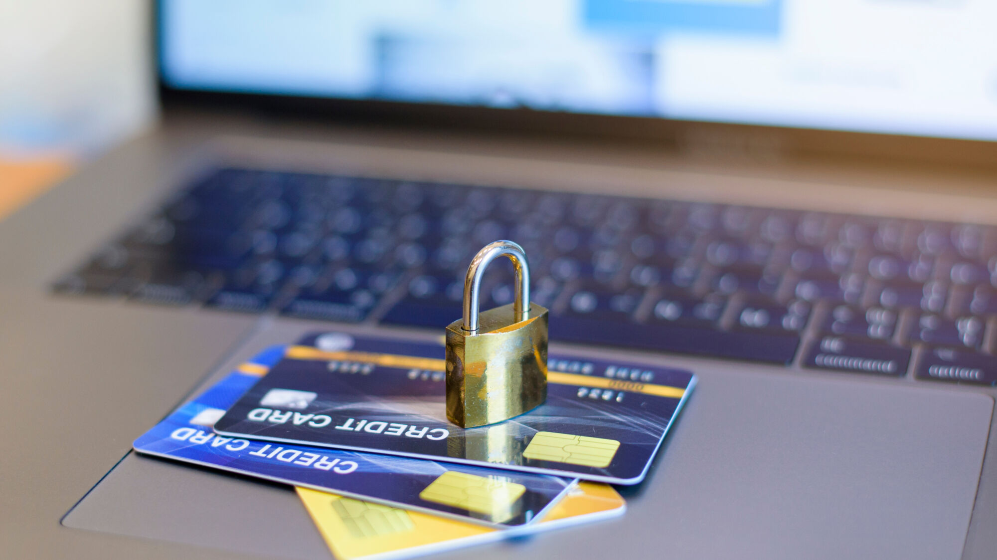 Carte de crédit sous un cadenas sur un clavier d'ordinateur, illustrant la sécurité des transactions en ligne.