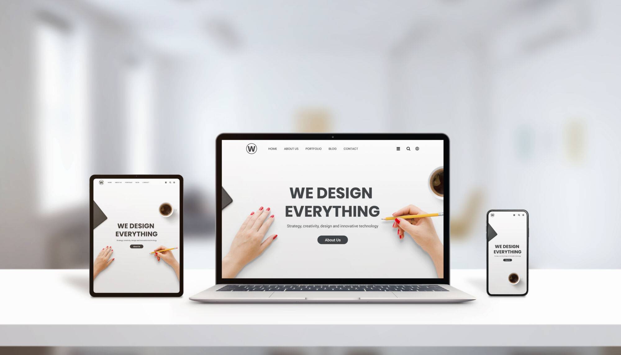 Appareils montrant un site web de design avec le slogan "WE DESIGN EVERYTHING", illustrant les services de conception web.