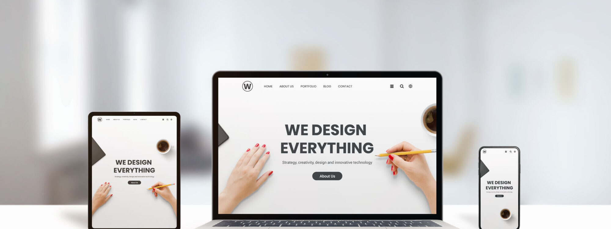 Appareils montrant un site web de design avec le slogan "WE DESIGN EVERYTHING", illustrant les services de conception web.