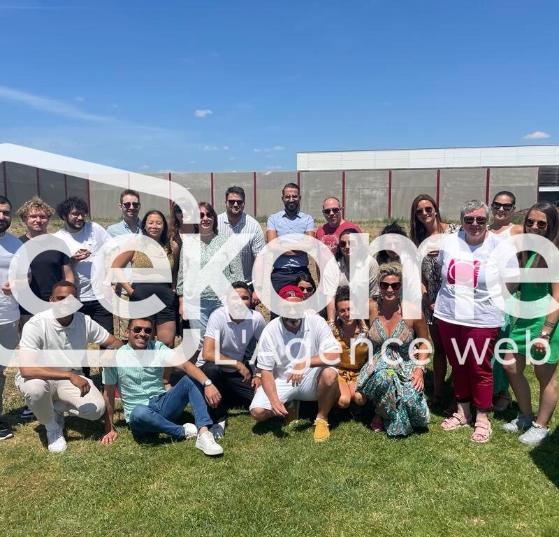 Photo de groupe en extérieur sur la pelouse devant le bâtiment de l'entreprise Cekome.