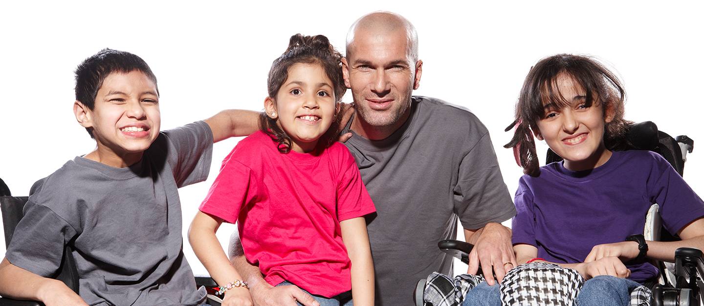 Zinedine Zidane souriant entouré d'enfants heureux.