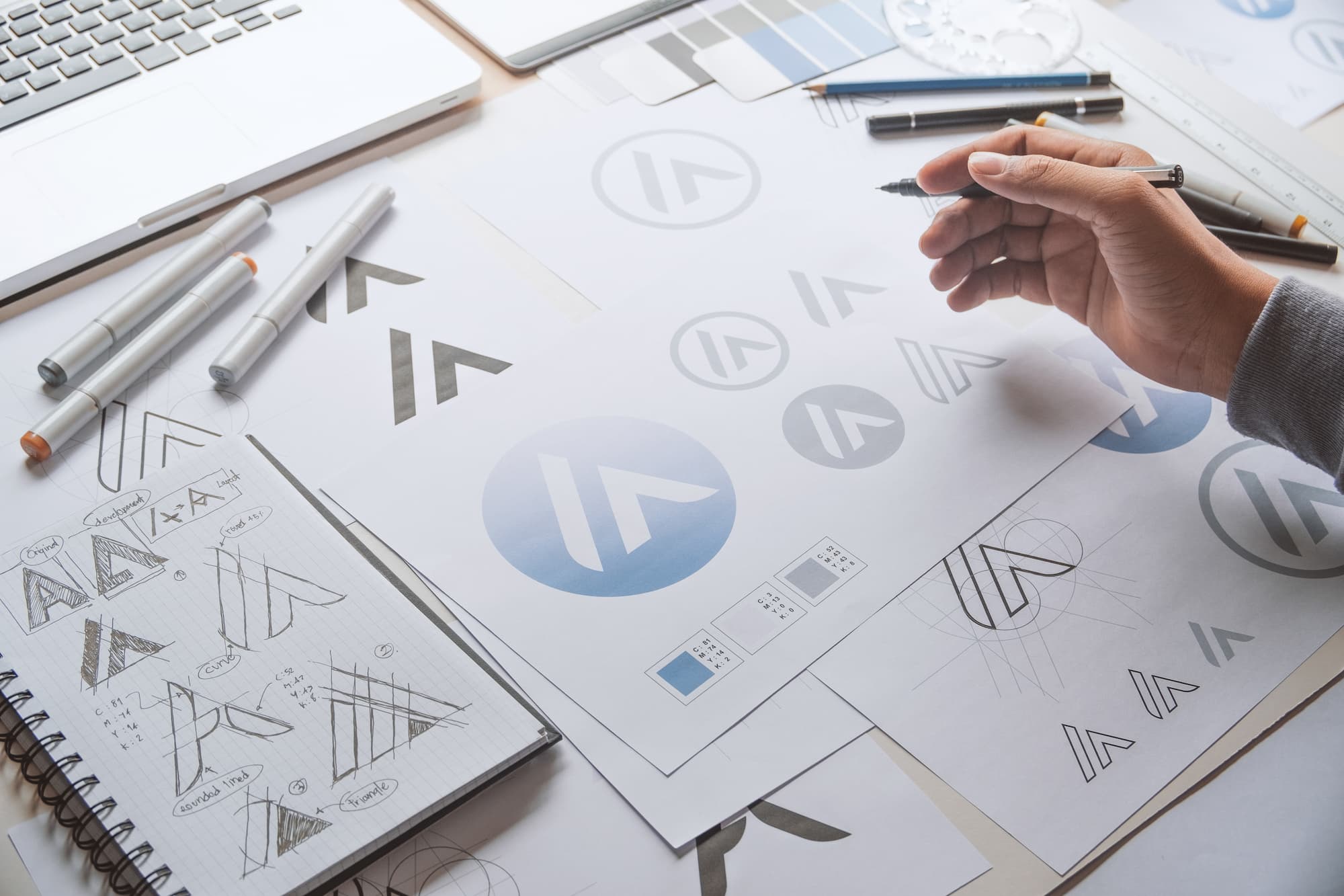 Planification de design de logo avec différents croquis et outils de dessin sur une table de travail