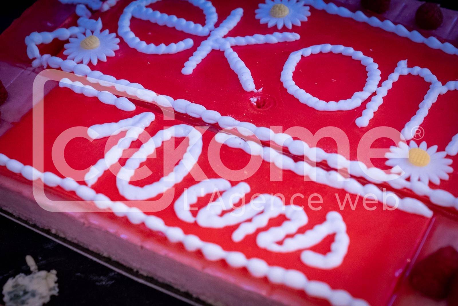 Détail d'un gâteau d'anniversaire avec le logo de Cekome célébrant 10 ans.