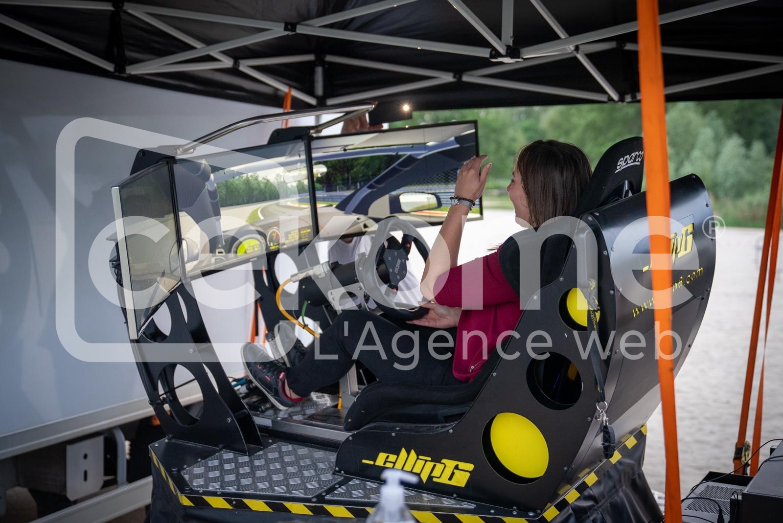 Personne utilisant un simulateur de course automobile lors d'une activité de Cekome.