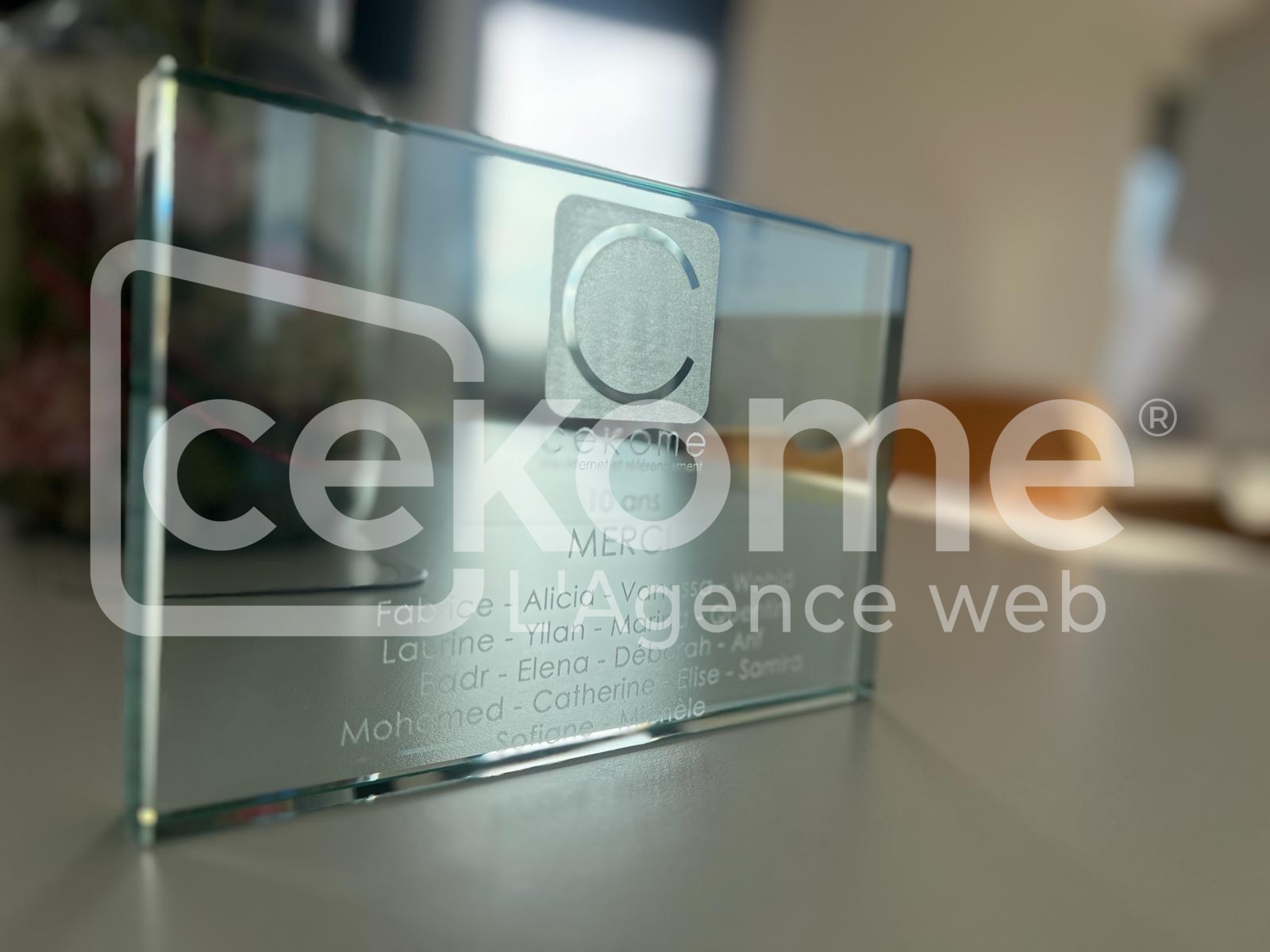 Trophée en verre personnalisé avec le logo de Cekome et des noms gravés.