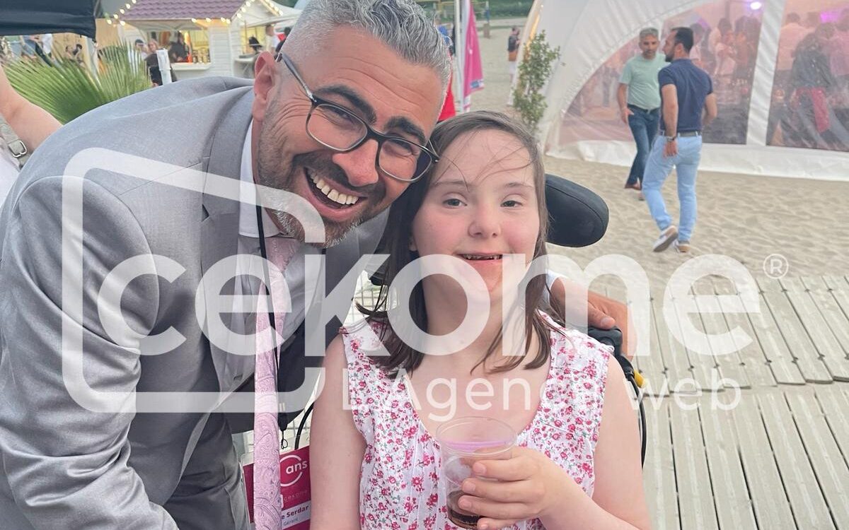 Homme souriant posant avec une jeune fille lors d'un événement de Cekome.