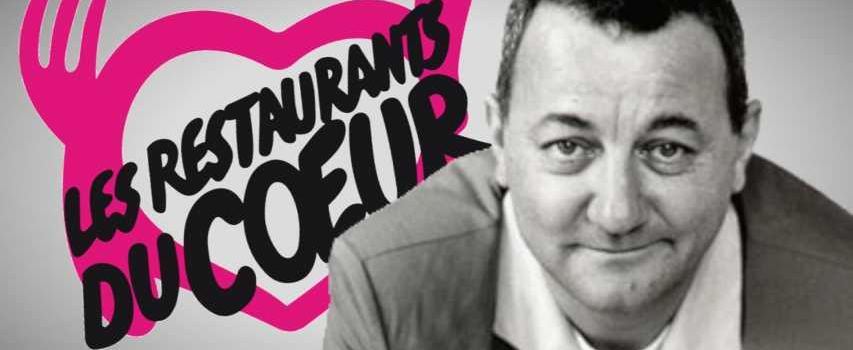 Affiche promotionnelle pour les Restaurants du Coeur avec le portrait de Coluche souriant.