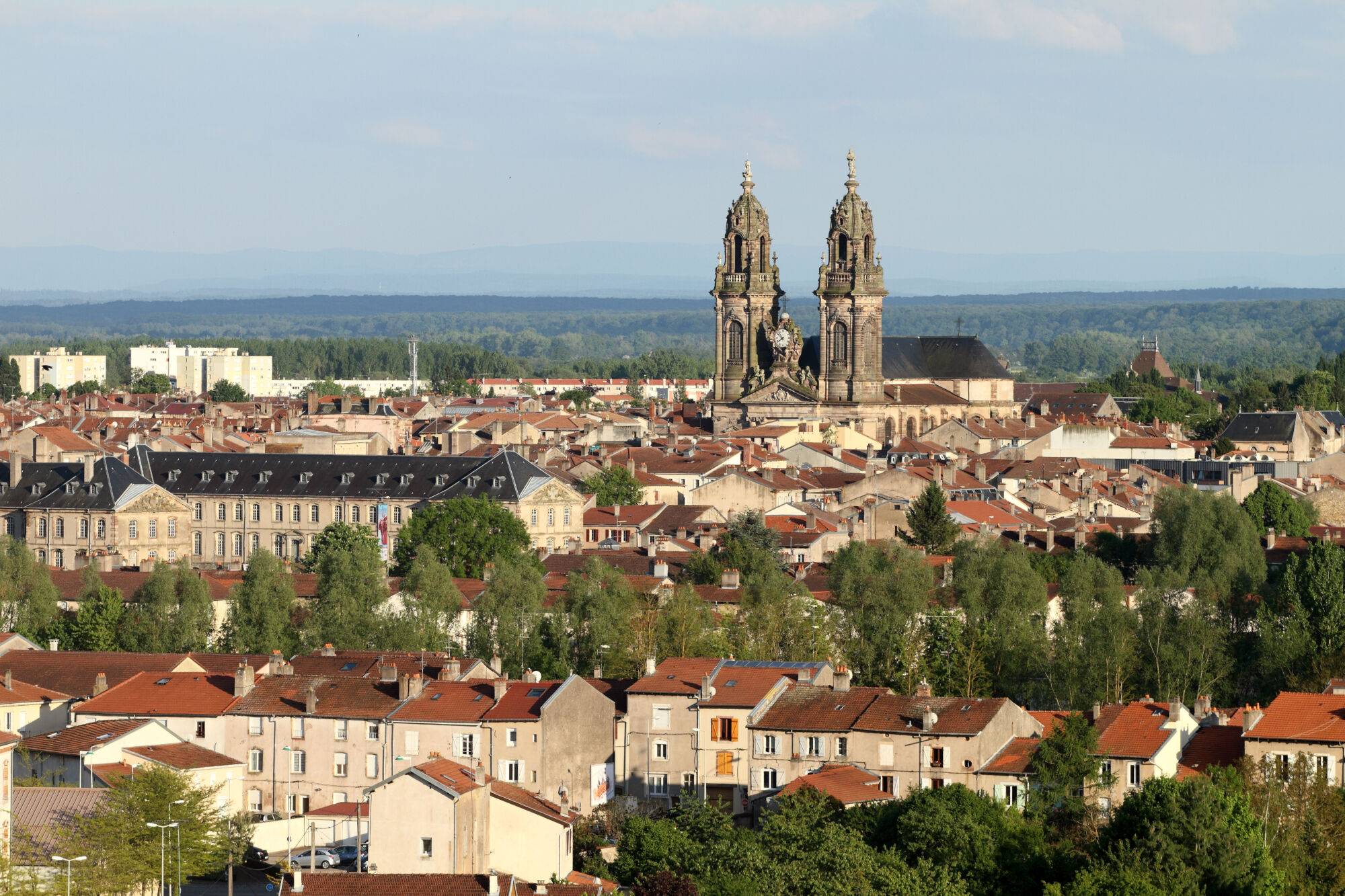 Vue panoramique sur une ville avec une cathédrale à deux clochers dominant les toits.