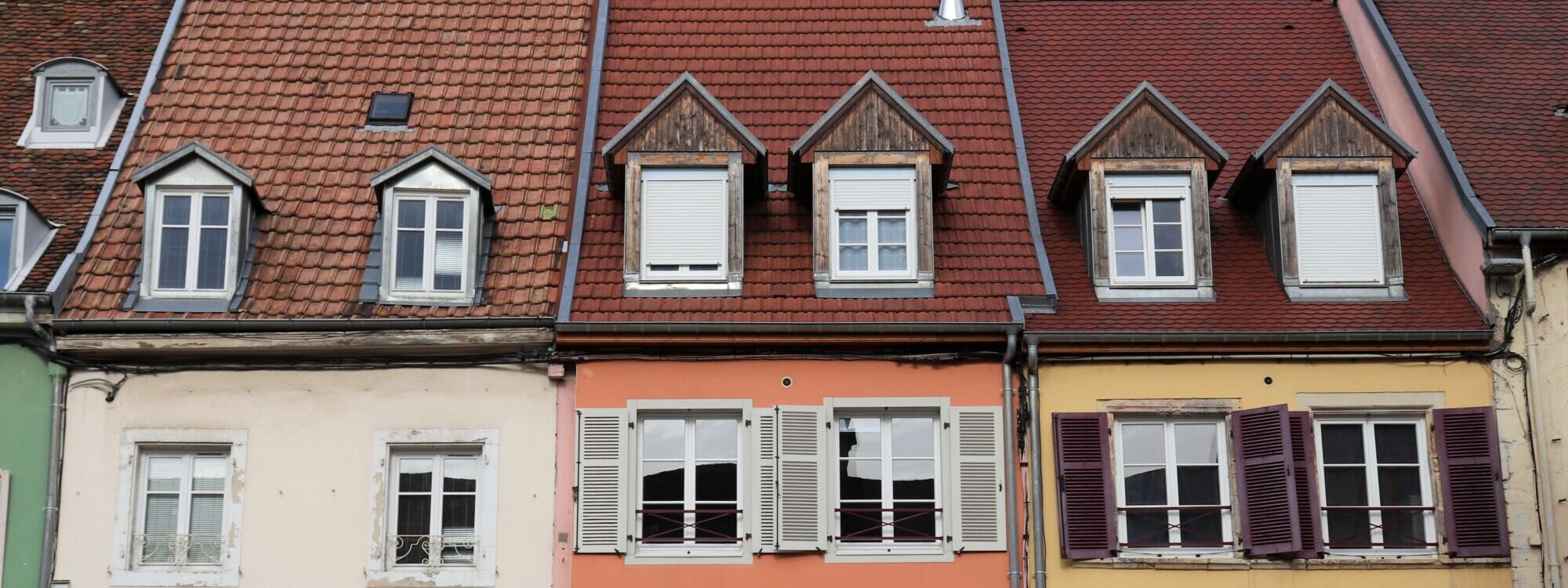 Façades colorées de maisons traditionnelles avec greniers et toits en tuiles.