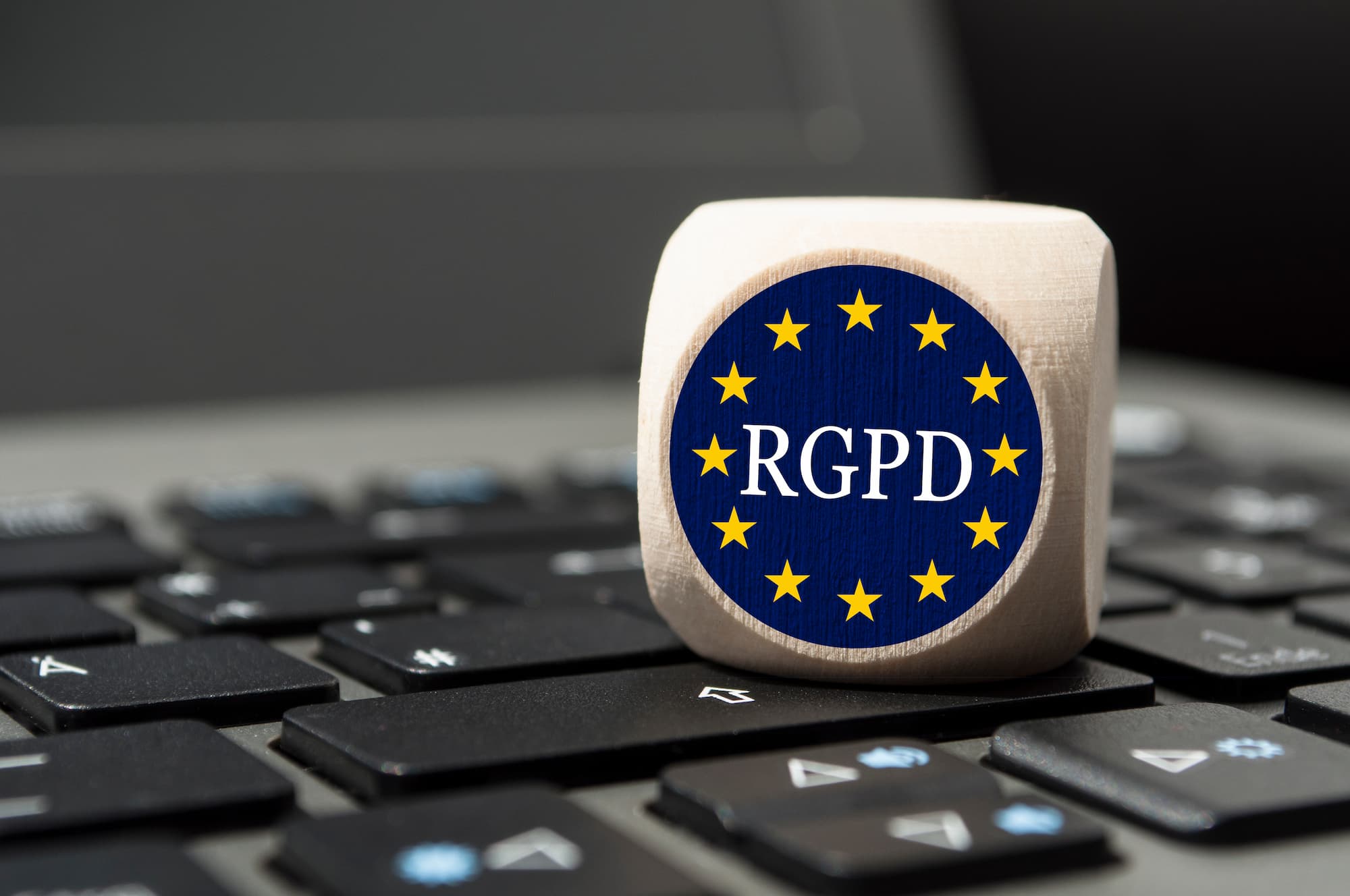 Dé déposé sur un clavier d'ordinateur avec le symbole RGPD pour représenter la conformité à la réglementation européenne.